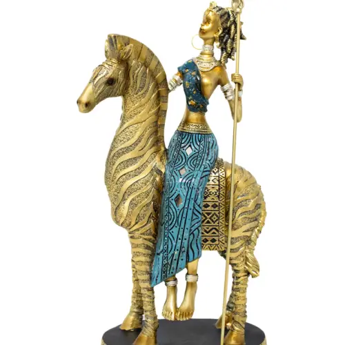 Africana de poliresina cabalgando caballo dorado con vestido azul y lanza diamantada de 19x9x33.5cm