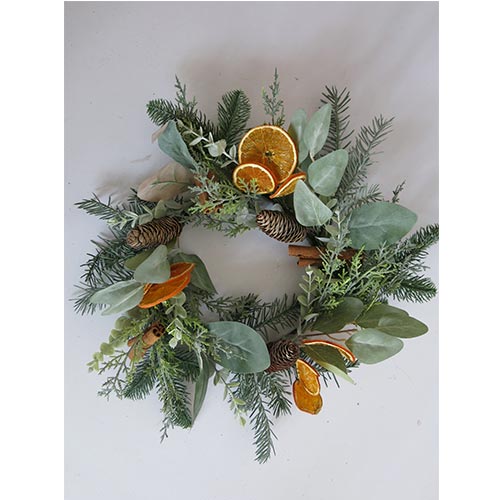 Corona de follaje verde con canelones rodajas de naranja y piñas de 45cm