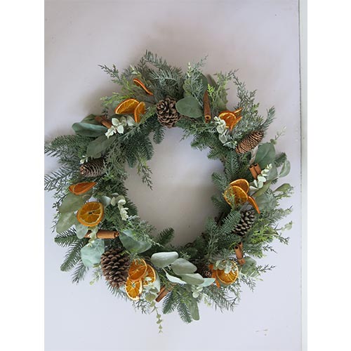 Corona de follaje verde con canelones rodajas de naranja y piñas de 73cm